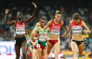 Jepkemoi of Kenya reacts as she crosse the finish line next to Ghribi of Tunesia and Krause of Germany the women's 3000m steeplechase final during the 15th IAAF World Championships at the National Stadium in Beijing