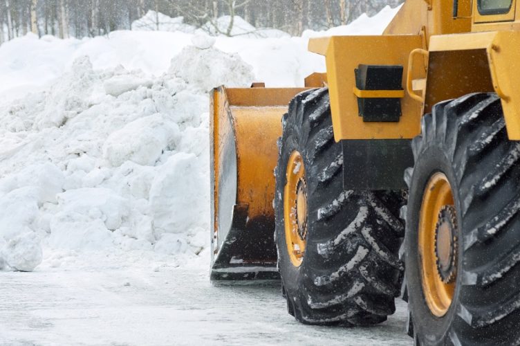 The bulldozer cleans the road after a blizzard