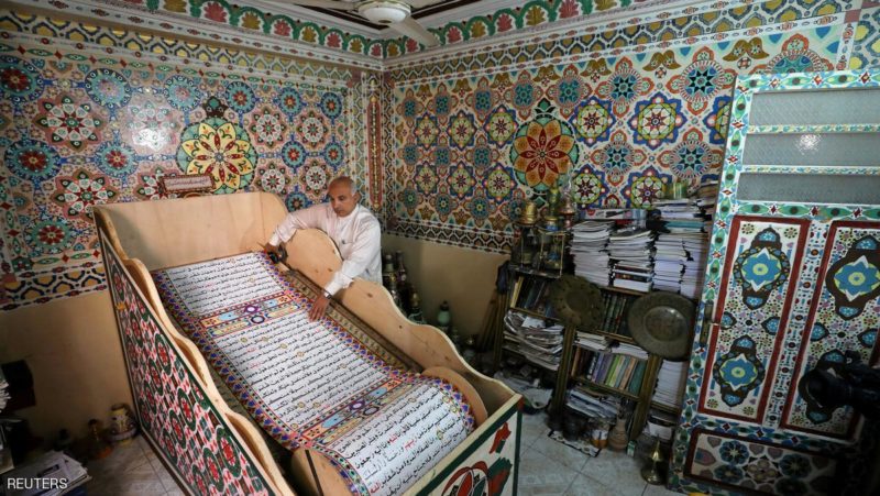 Saad Mohammed rolls down what he says is the largest handwritten version of Koran in the world, the town of Belqina