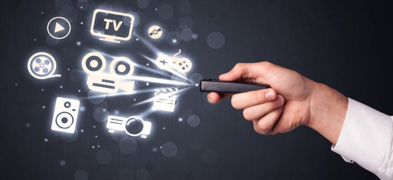 Hand with remote control and media icons