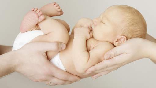baby newborn sleeping on parents hands, kid and family concept